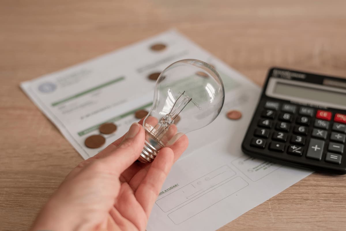 Bombilla sobre una factura de luz y gas con centimos de yoigo